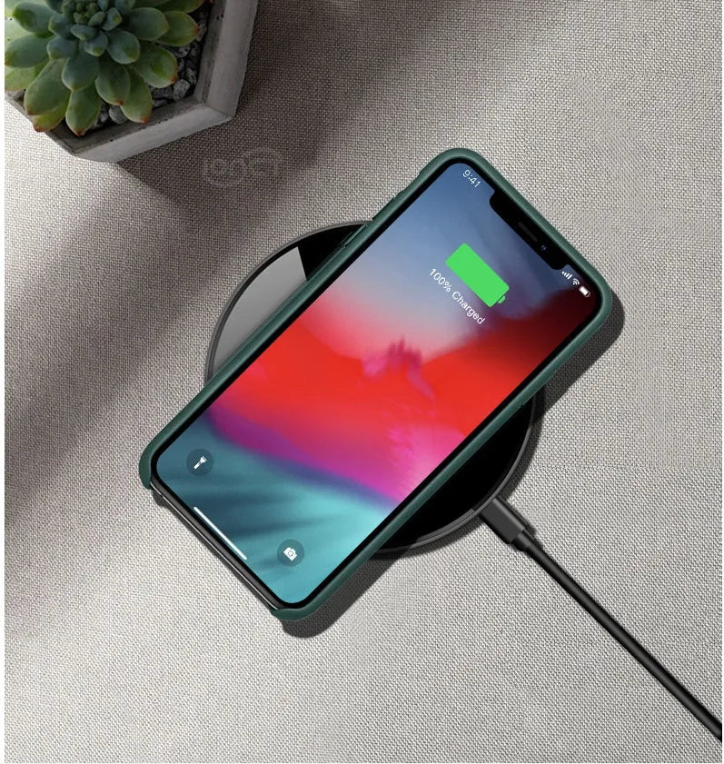 Black QI wireless charging pad with a smooth plastic surface and silicone non-slip base.