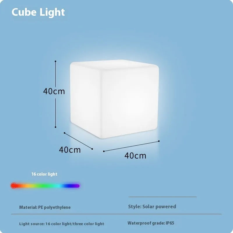 Modern square LED cube stool light outdoors, functioning as both a garden seat and a waterproof light source.