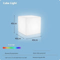Modern square LED cube stool light outdoors, functioning as both a garden seat and a waterproof light source.