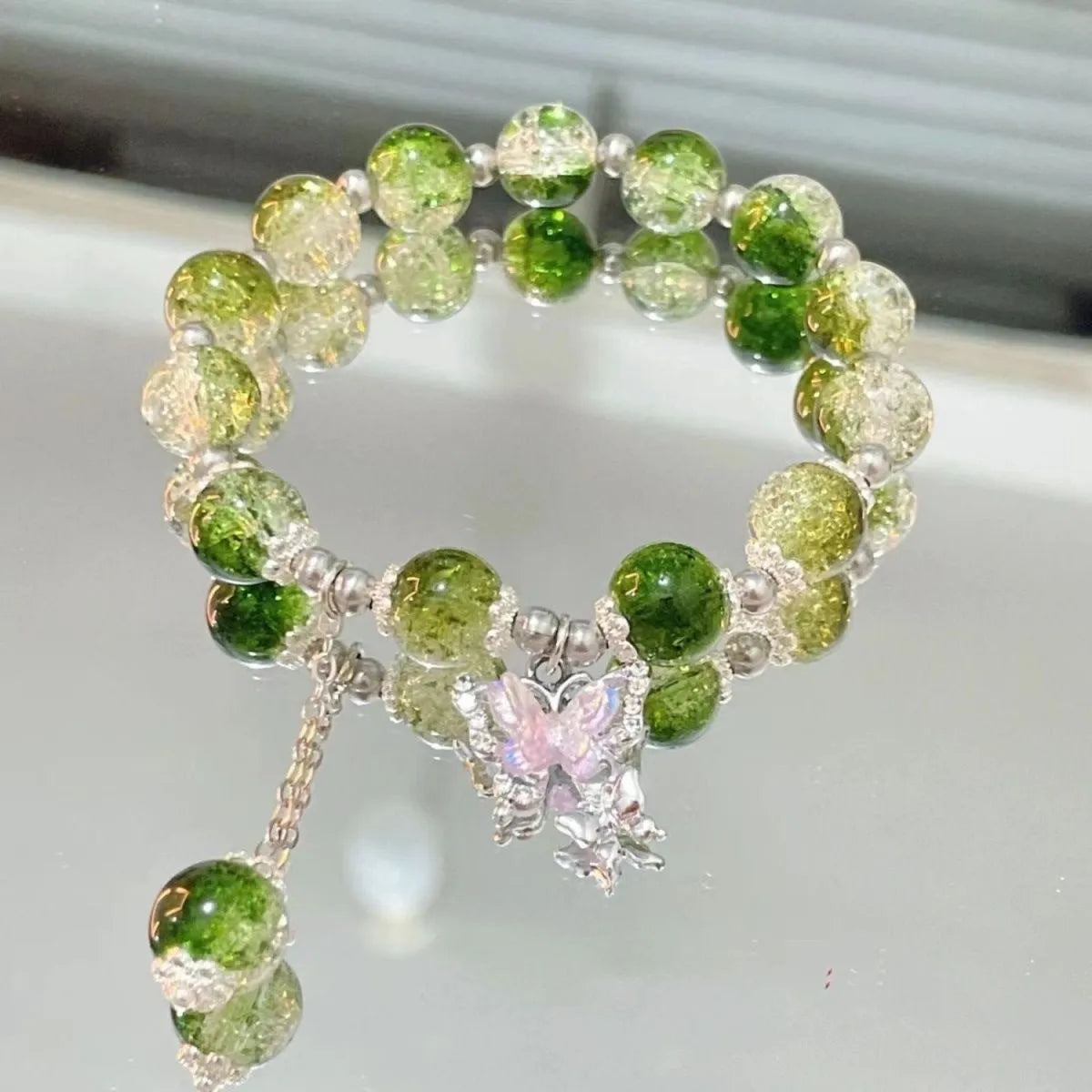 Handmade glass bead bracelet with fairy butterfly broken beads design on white background