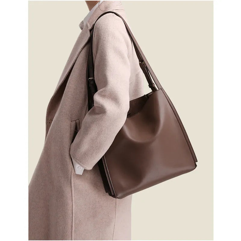 Brown genuine leather women's bucket bag with double shoulder straps and internal compartments.