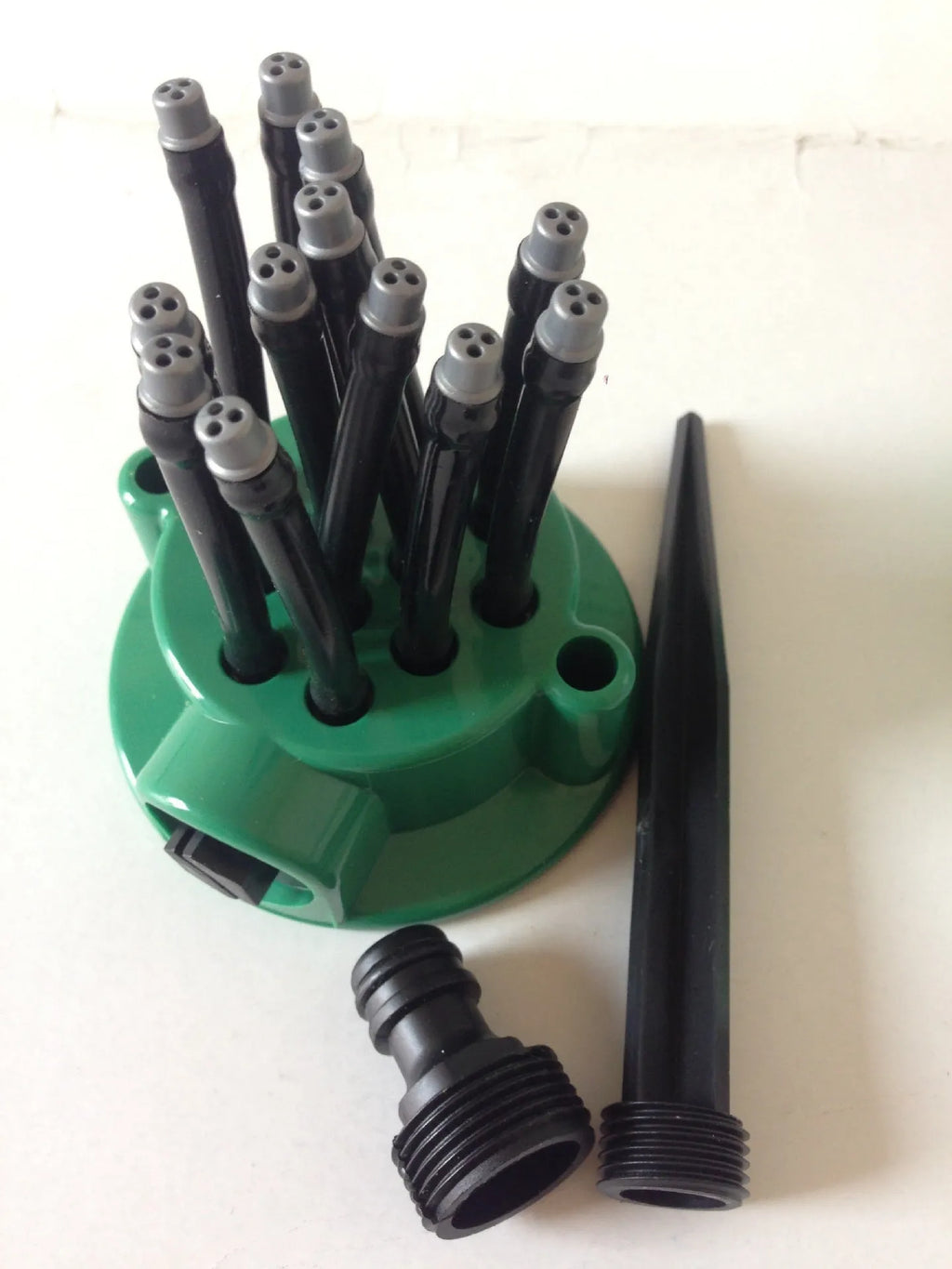 Green adjustable lawn sprinkler with flexible water distribution arms