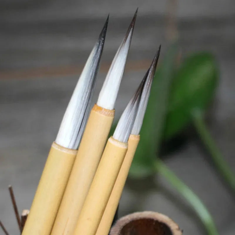Four Chinese calligraphy brushes with mixed wolf wool and goat hair bristles on gold lacquer wooden bodies