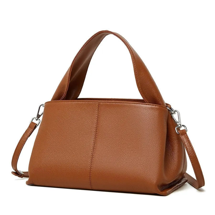 Women's brown retro texture leather messenger bag with a double shoulder strap shown on a table.