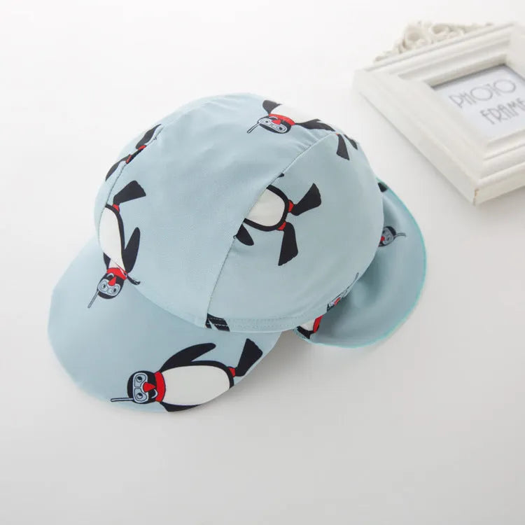 Boy's long sleeve penguin print swimsuit and matching swim cap set on a white background
