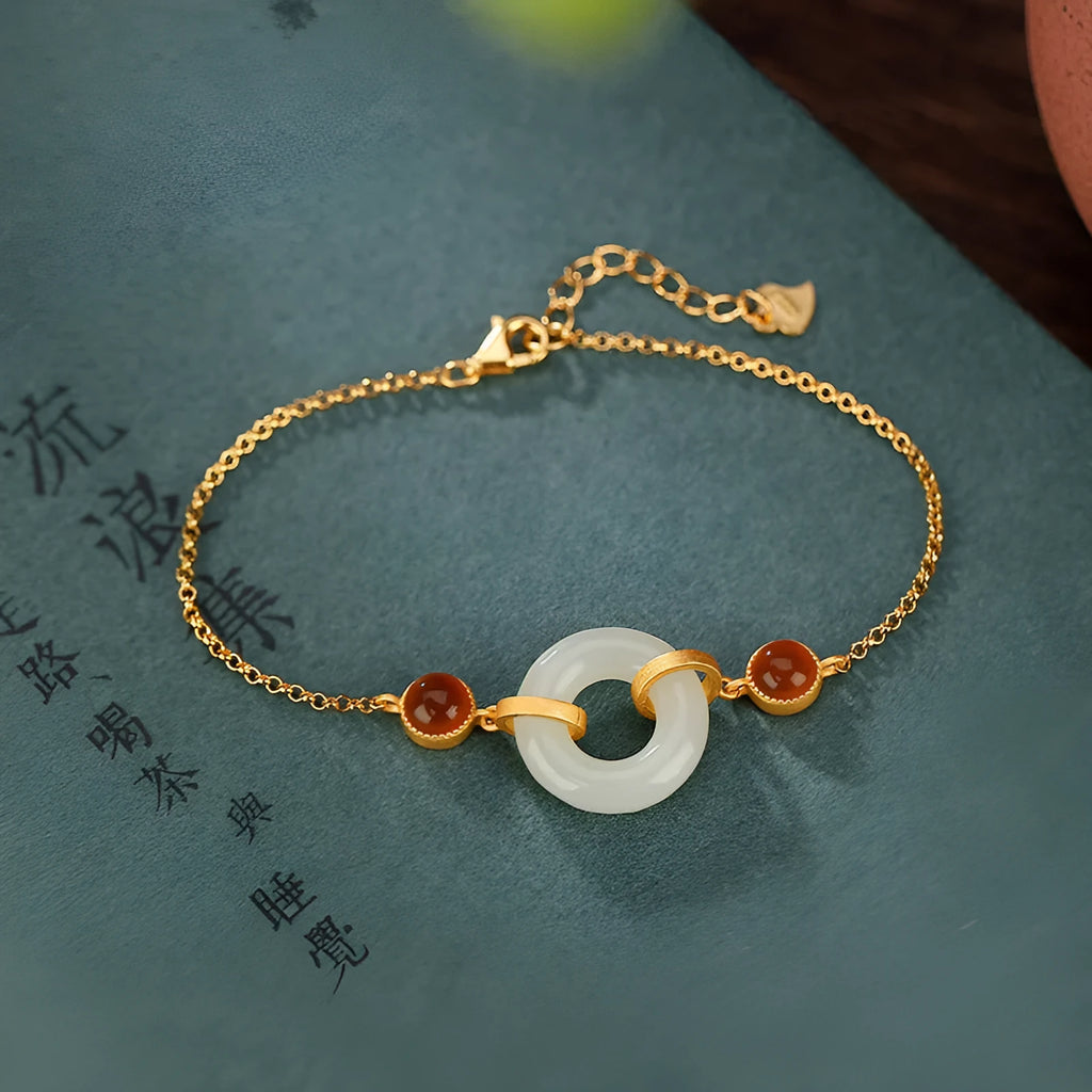 Women's sterling silver bracelet with gold-plated finish and natural Hetian jade peace buckle on adjustable chain