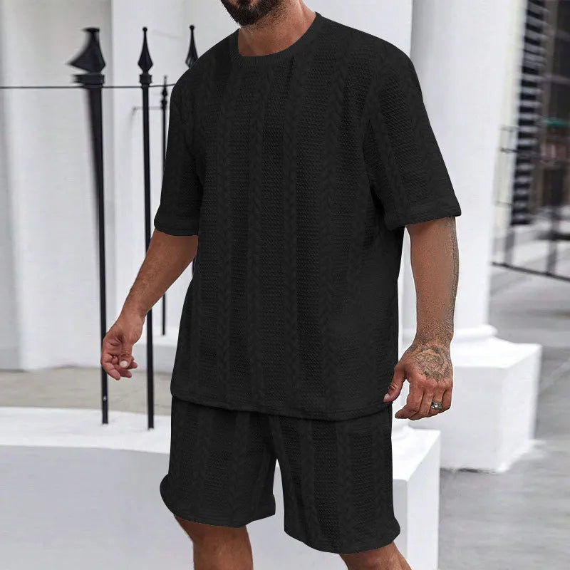 Knitted solid colour short sleeve pullover and matching shorts laid flat.