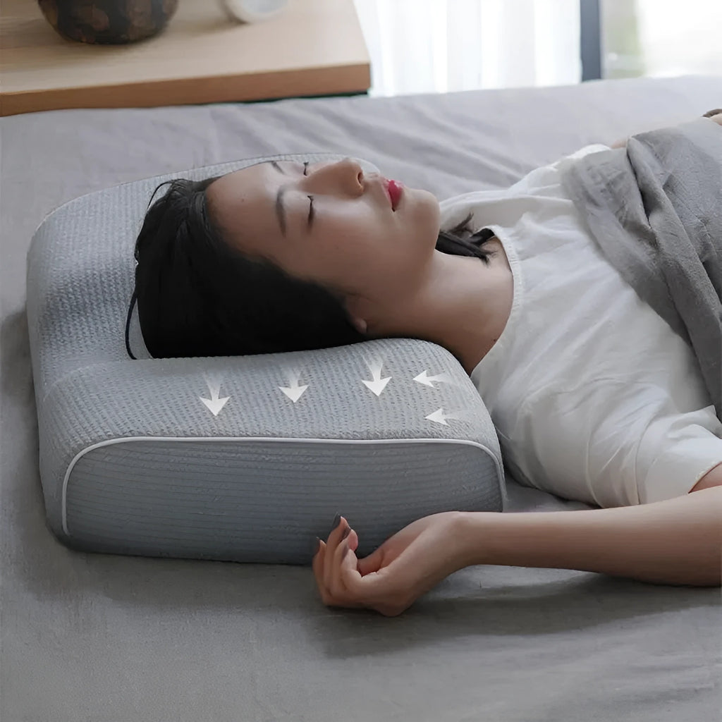 Grey memory foam massage pillow with knitted cotton cover on a bed, offering adjustable neck support for sleep