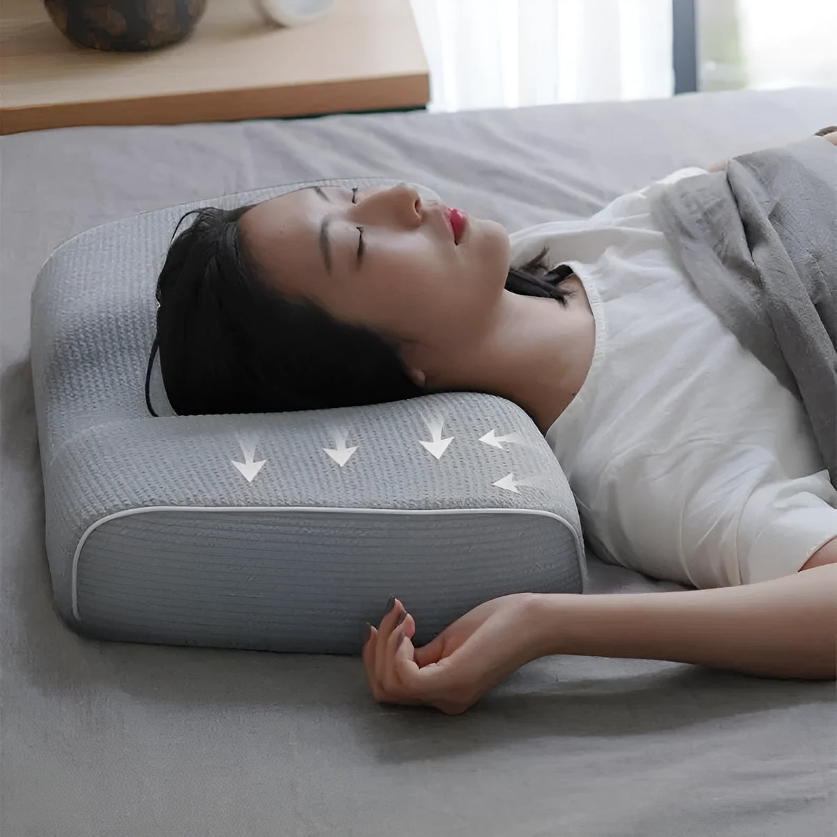 Grey memory foam massage pillow with knitted cotton cover on a bed, offering adjustable neck support for sleep