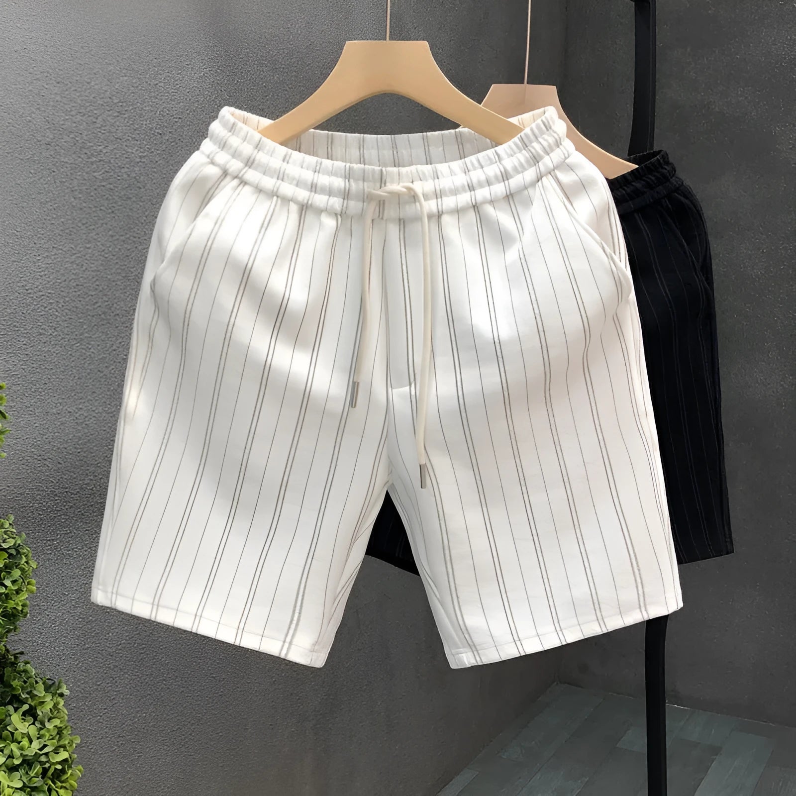 Men's black and white striped fleece-lined casual shorts on a neutral background.