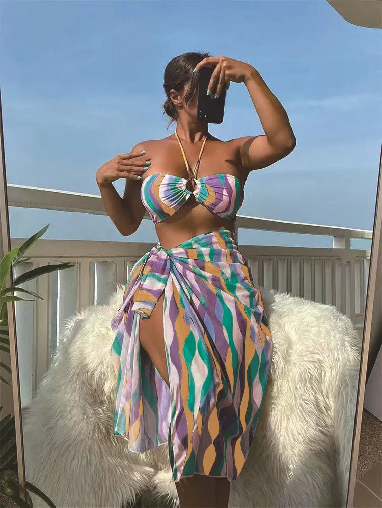 Women's yellow green printed three-piece bikini set with a matching skirt laid flat.