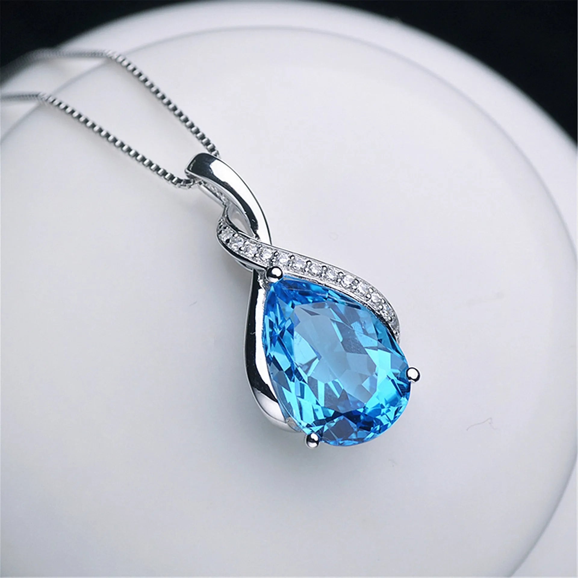 Copper drop shape pendant necklace with electroplated finish on a dark blue diamond square chain
