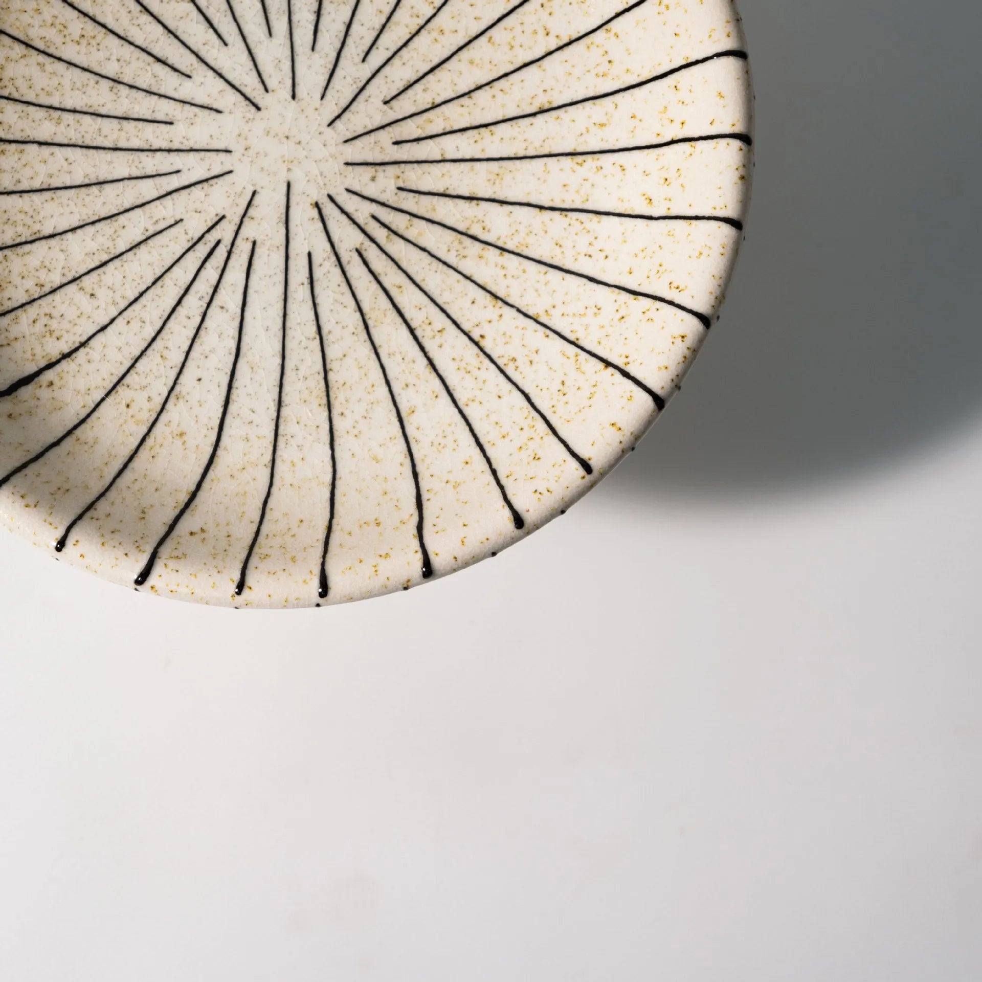 Black and white striped synthetic resin fruit plate on a wooden surface.