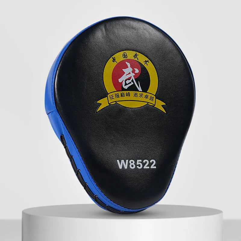 Red and black curved boxing punch mitts held in a trainer's hands for Muay Thai or Sanda practice.