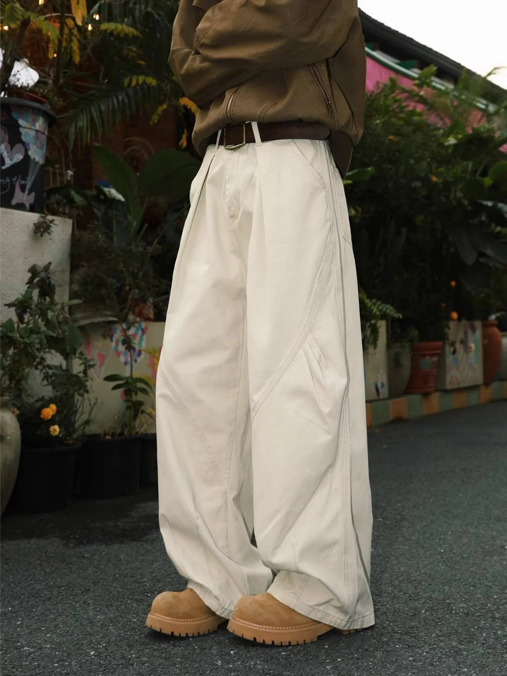 Men's pleated straight-leg trousers in a striped pattern, showing loose fit and straight hem.