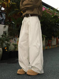 Men's pleated straight-leg trousers in a striped pattern, showing loose fit and straight hem.