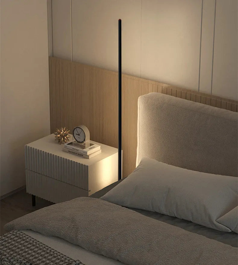 Tall, slim aluminium alloy vertical LED floor lamp standing beside a modern sofa.
