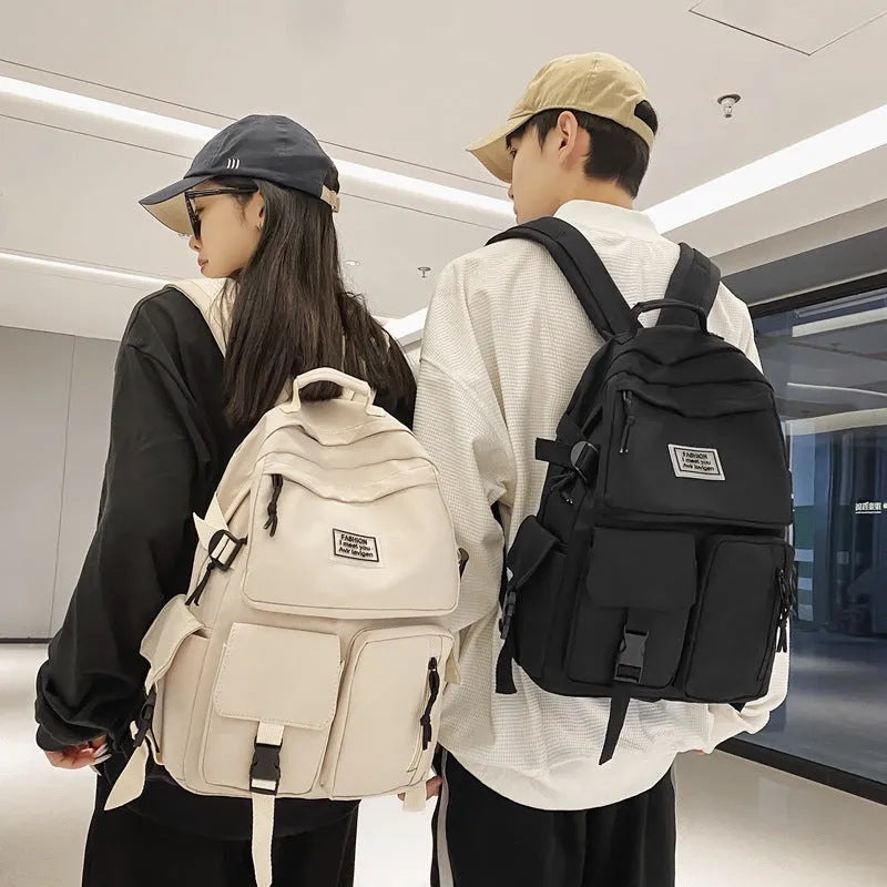 Black and white nylon student backpack with laptop compartment and 3D pockets.