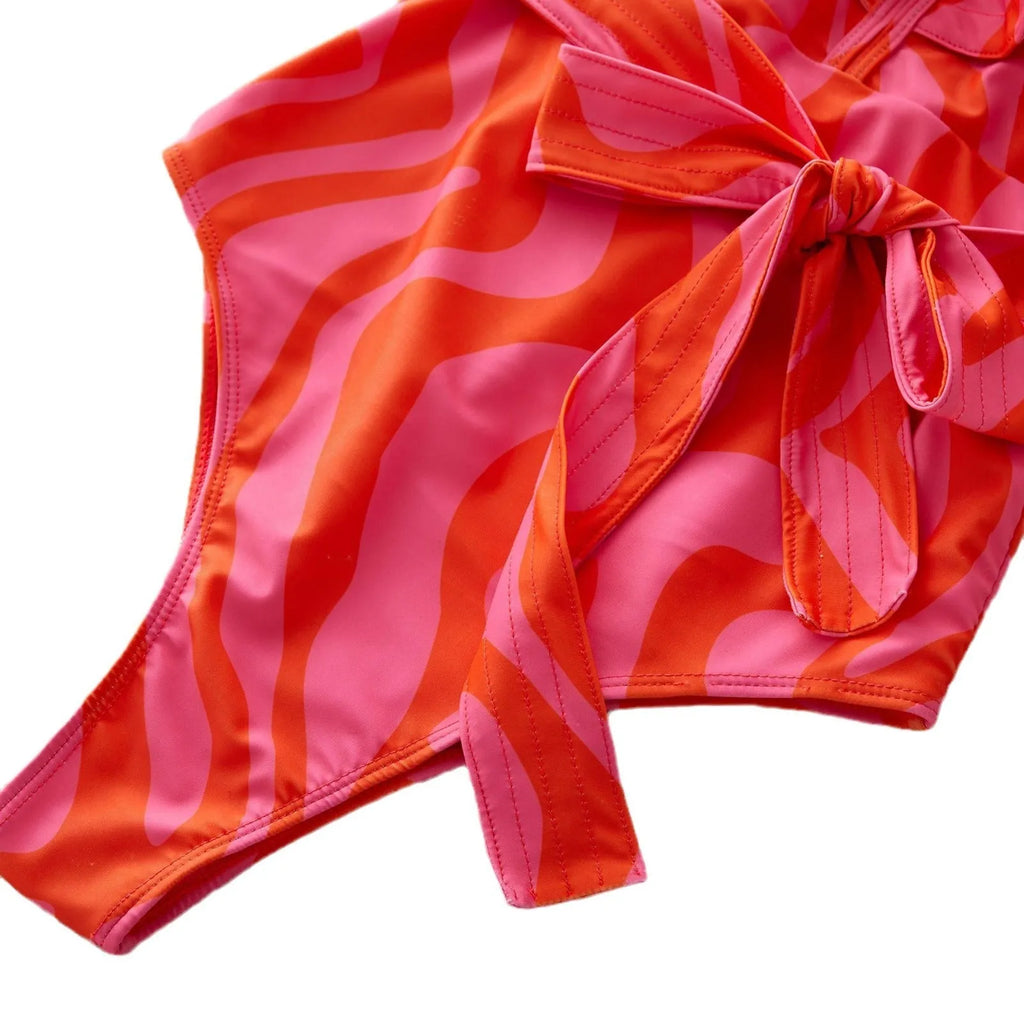 Women's one-piece swimsuit with ruffled straps, deep V-neck, and mesh stitching in a printing colour pattern.