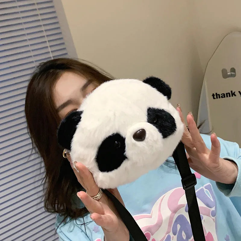 Soft plush panda head design crossbody bag showing cylindrical shape and outer pocket.