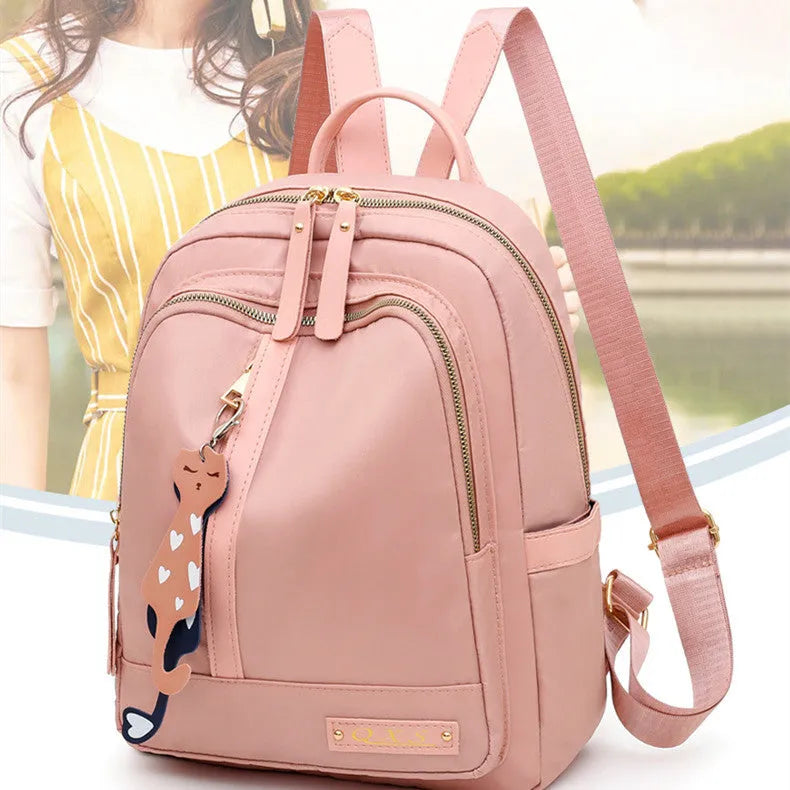Black nylon casual backpack with external pockets, shown with adjustable straps and a soft handle.