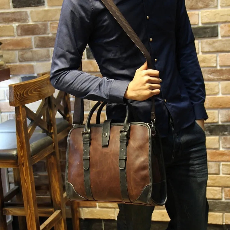 Men's cowhide leather brown business messenger bag with zip closure and shoulder strap on a wooden table