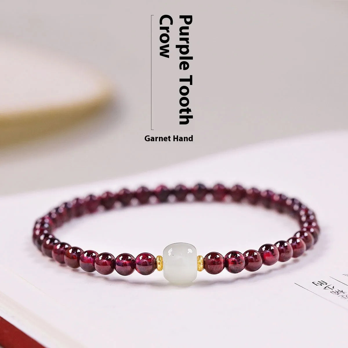 Women's garnet bracelet with U-shaped design showing polished stones in garnet colour