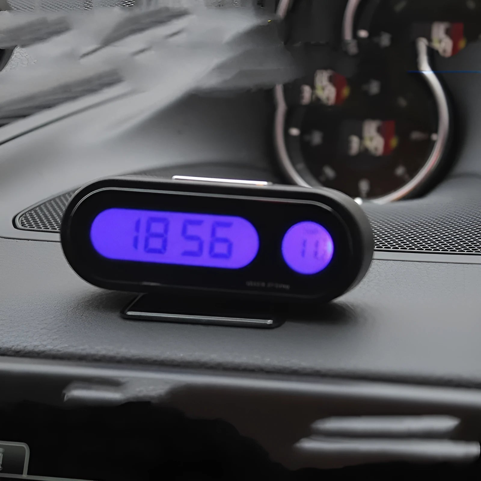 Black electronic car clock and thermometer on an adjustable bracket with luminous LED display.