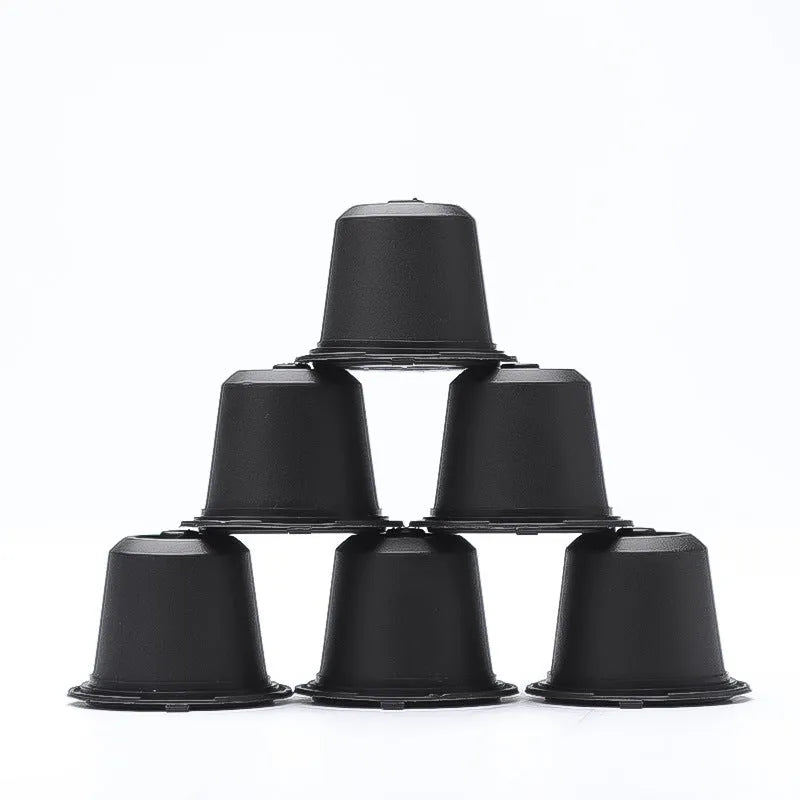 Six recyclable coffee shell filter cups in black, brown, and red plastic with a spoon