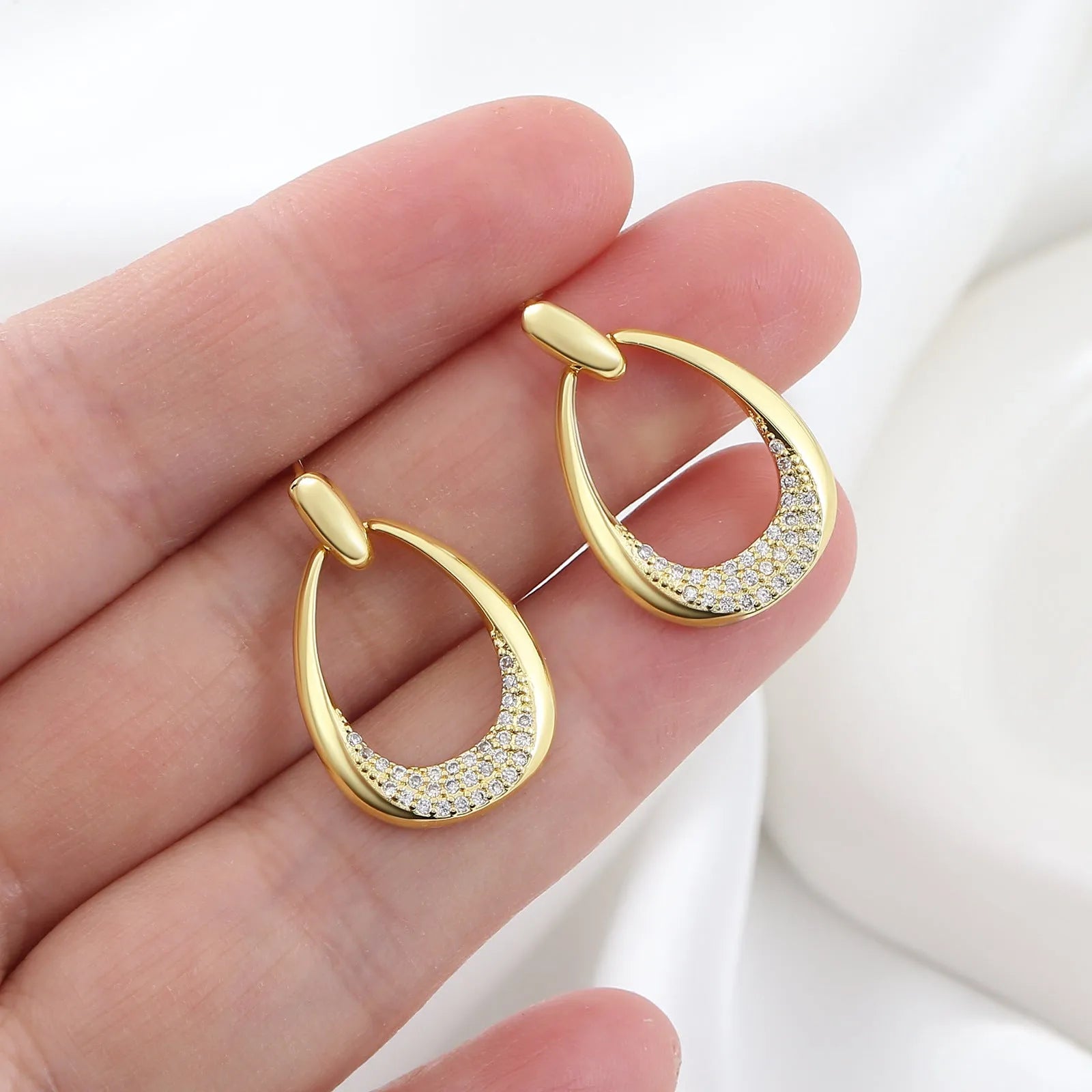 Yellow gold geometric drop earrings for women with simple zircon details on a copper base.