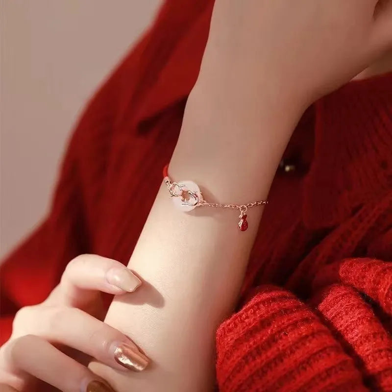 Red rope women's bracelet with peace buckle clasp and festive koi fishtail design