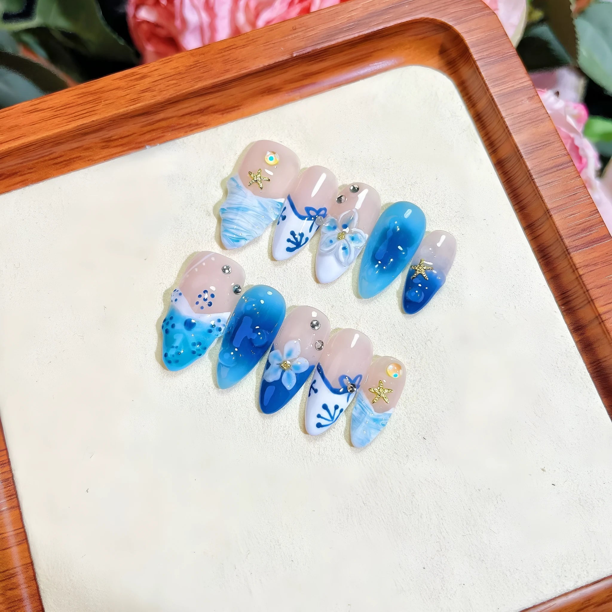 Blue hand-painted carved fake nails set with floral designs in sizes XS S M L