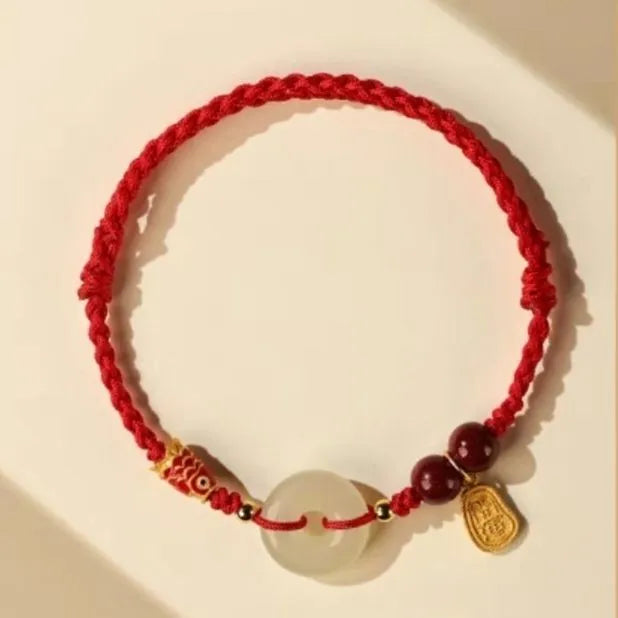 Handmade bracelet with Hetian jade peace buckle charm on adjustable braided rope.