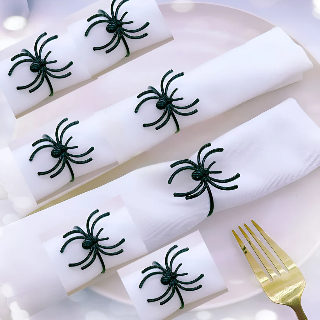 Six black metal spider-shaped napkin rings for Halloween table decoration.