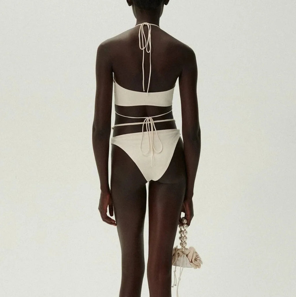 Women's black split lace-up bikini swimsuit with brief shorts and sleeveless bra top.
