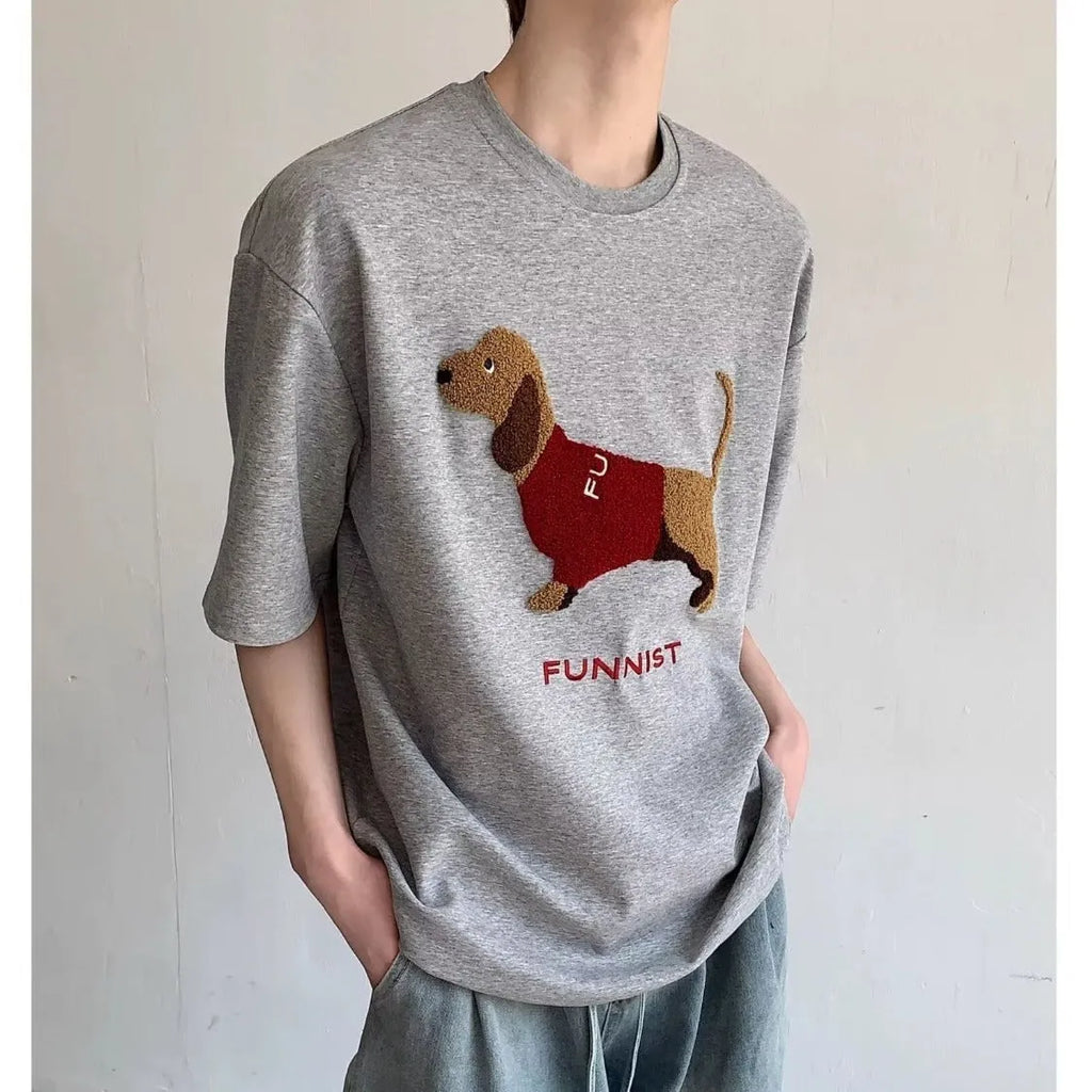 Men's grey cotton T-shirt with an embroidered sausage dog on the chest, showing short sleeves and a round neck.