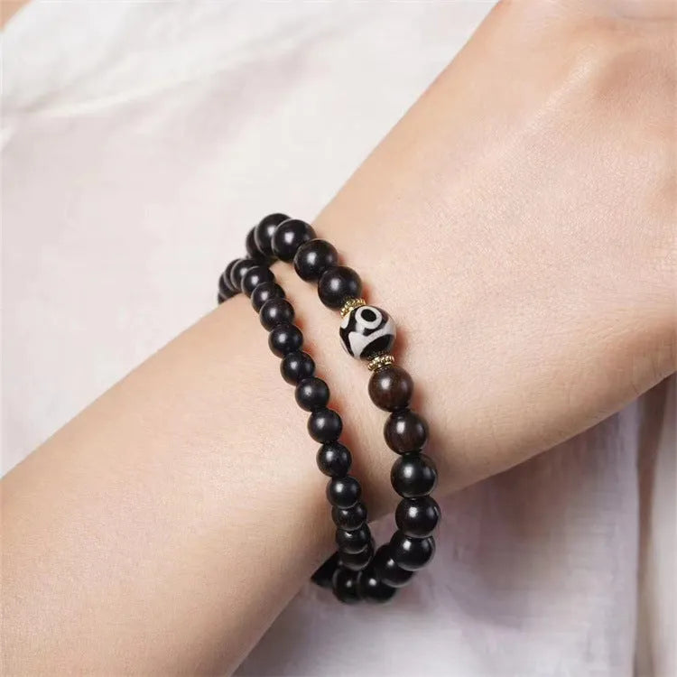 Dark ebony wood bracelet with 8mm Tibet-style beads and circle elements on wrist