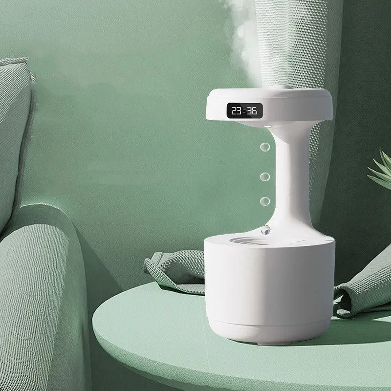 White anti-gravity humidifier with LED clock display emitting mist on a wooden desk.