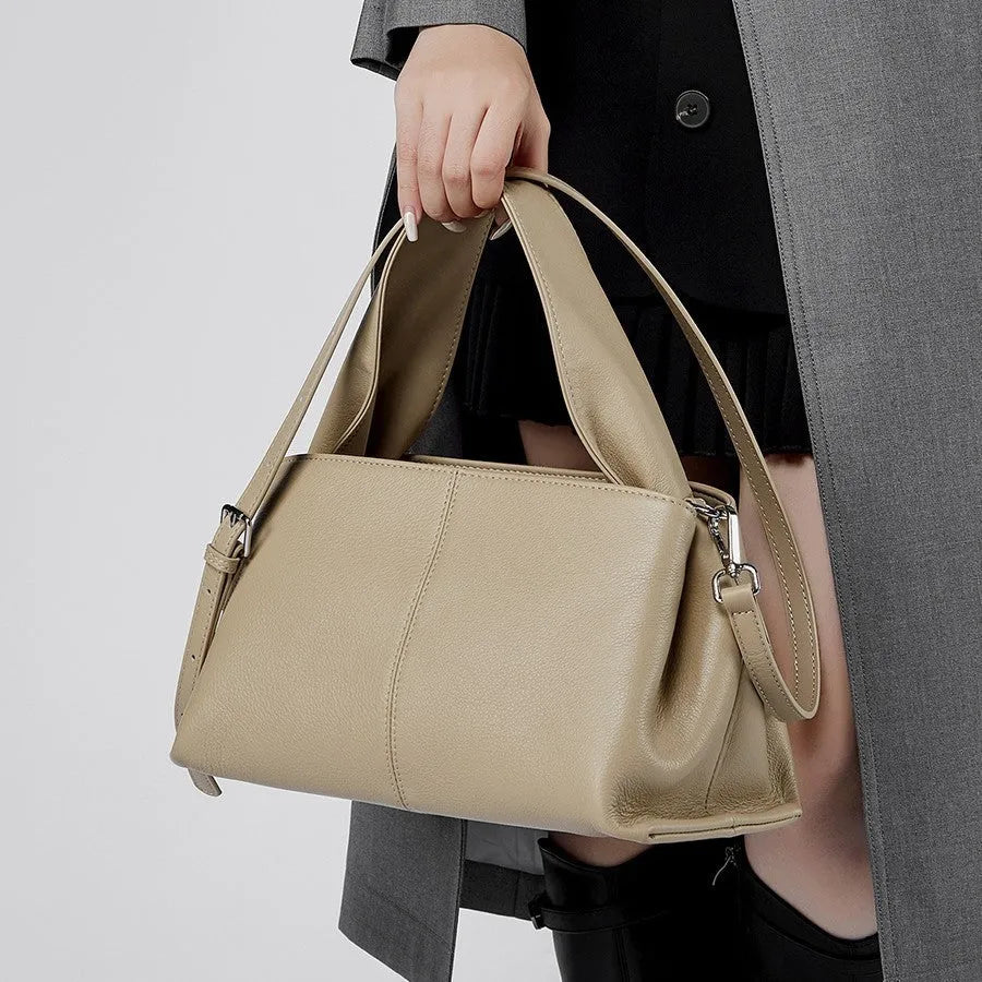 Women's brown retro texture leather messenger bag with a double shoulder strap shown on a table.