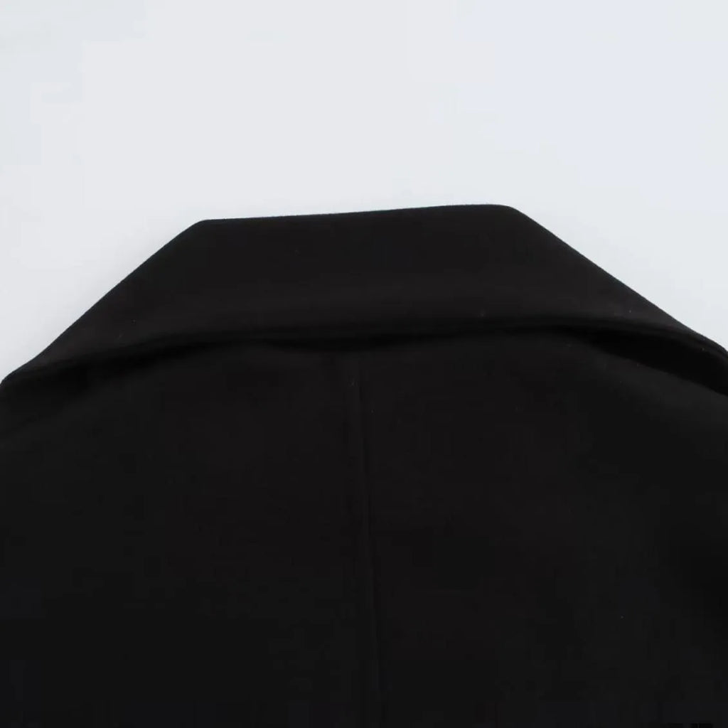 A woman wearing a longline black polyester coat with a detachable faux fur collar.