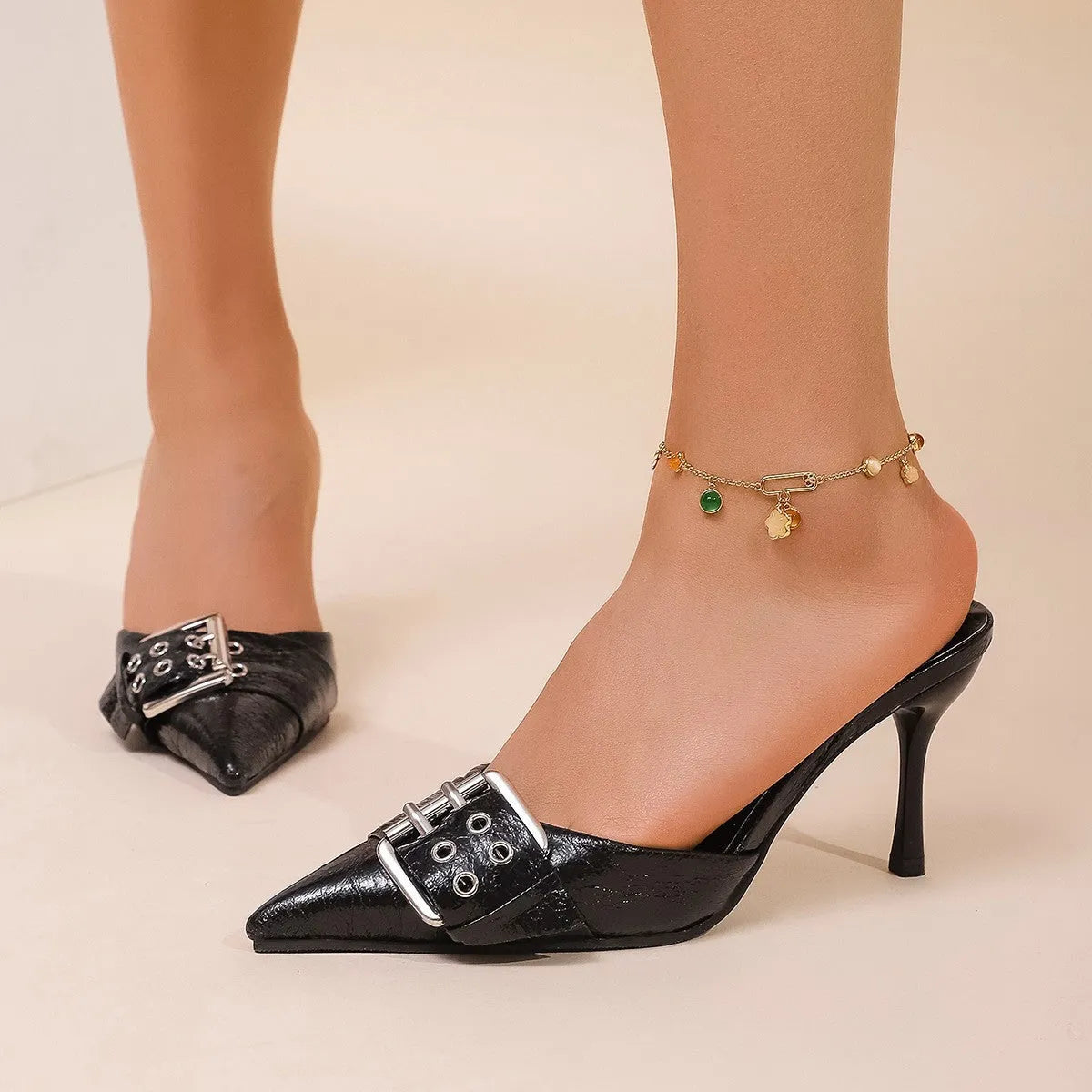 Black women's high heels with pointed toe and buckle strap detail in PU material