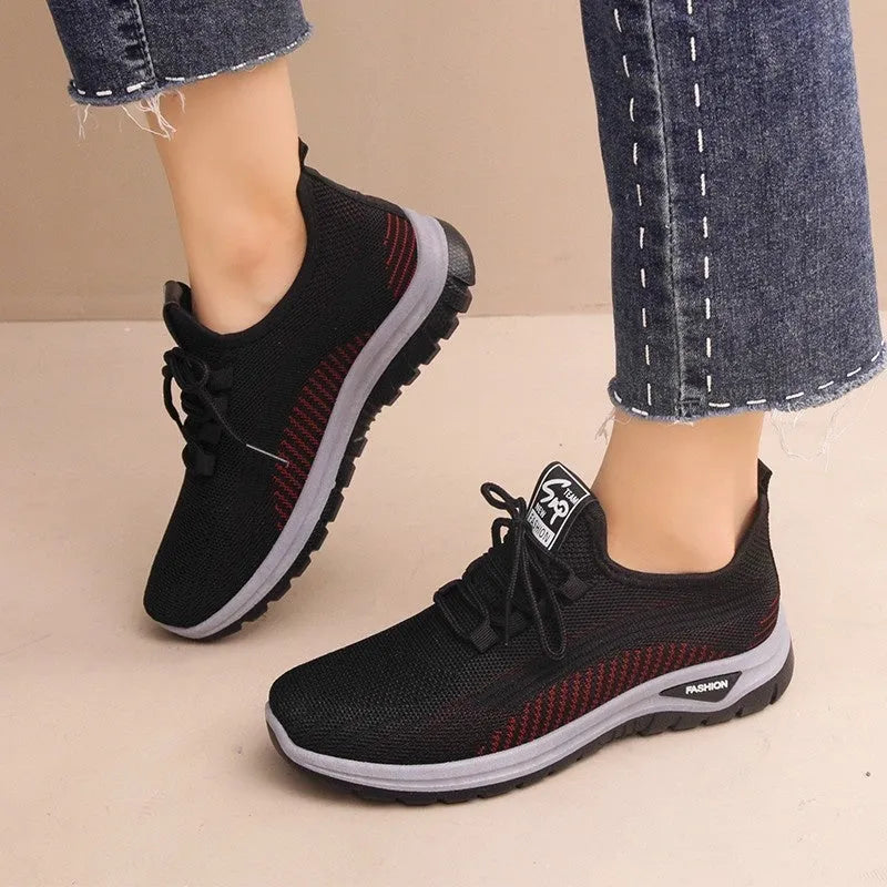 Women's black mesh sneakers with round toe, cross-strap details, and lace-up front on rubber sole