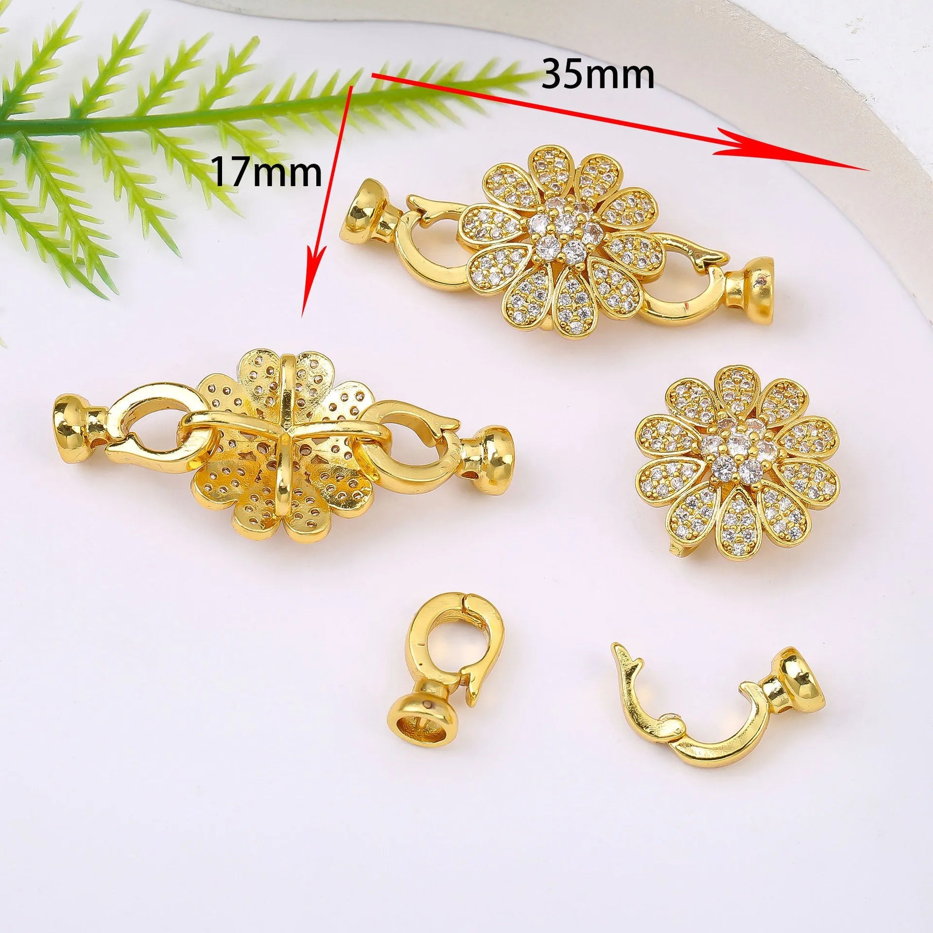 Small gold-plated necklace chain buckle on a white background, a DIY jewellery finding.