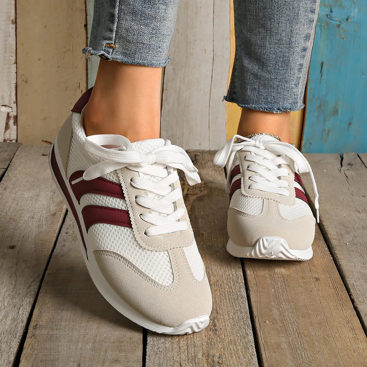 Wine red casual sneakers with cross straps over a breathable mesh and synthetic leather upper.