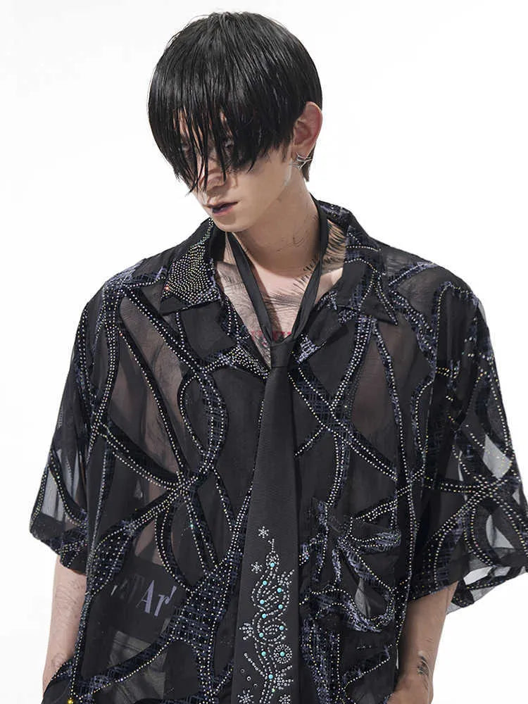 Man's black and grey snake pattern short-sleeved shirt with loose fit and lapel collar.