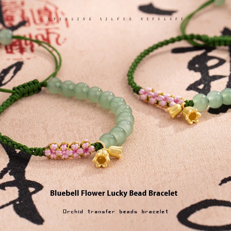 Close-up of a hand-woven red rope bracelet with floral design details on a wrist.