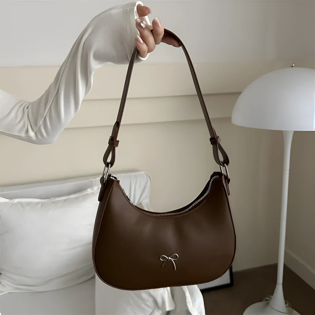 Small dumpling-shaped PU leather shoulder bag for women in multiple colours, showing the single strap and external pocket