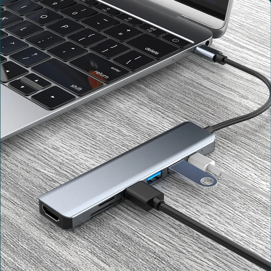 Seven-port USB-C hub expander with short cable shown next to a laptop.