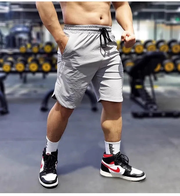 Men's black quick-dry running shorts with contrast blue stitching, shown flat.