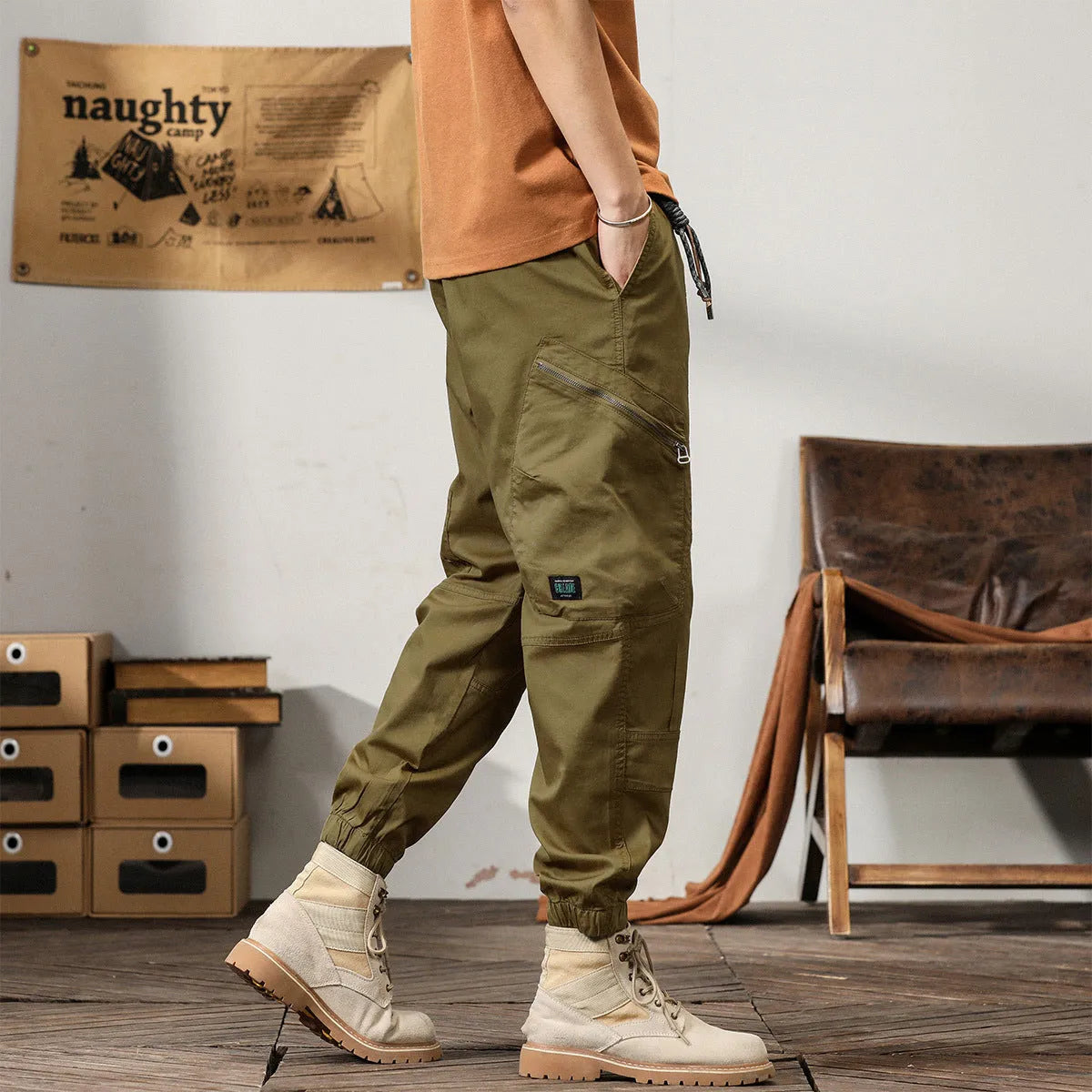 Man wearing khaki loose-fit cotton harem pants with tapered ankle-banded legs.